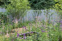 Auges en acier situées au milieu d'une plantation mixte avec en toile de fond une clôture peinte en bleu - Southend Young Offenders 'A Place to Think', RHS Hampton Court Palace Flower 2018