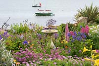 Cadran solaire immergé dans les vivaces à fleurs et les annuelles dans le jardin en bord de mer.