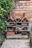 Une maison à insectes construite à partir de tuiles, de morceaux de bois, de briques et de morceaux d'ardoise et de pots en argile cassés