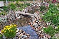 Briques concassées recyclées le long d'un ruisseau peu profond, Finding Urban Nature Garden, parrainé par Grass Roof Co, Global Stone, GreenBlue Urban, RHS Tatton Park Flower Show, 2018.