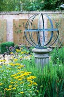 Cadran solaire armillaire en parterre de fleurs mélangé. Conception de jardin par Peter Reader Landscapes.