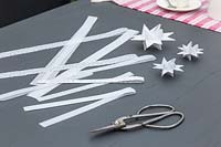 Matériaux et outils pour créer des étoiles en papier 3D décoratives.
