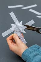 Femme coupe l'excès de papier hors décoration étoile 3D.