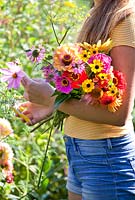 Fille cueillant des fleurs pour des compositions florales.