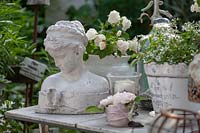 Collection d'articles vintage sur le thème blanc sur une table. Il s'agit notamment d'un buste de tête de femme et de plantes en pot à fleurs blanches.
