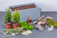 Ingrédients et outils pour planter une boîte de Pâques décorative.