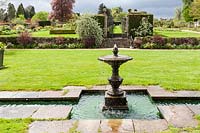 Fontaine et piscine à côté de la maison. Jardin Miserden, près de Stroud, Gloucestershire, Royaume-Uni.