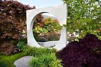 Vue à travers une ouverture circulaire en sculpure carrée dans le jardin d'exposition 'At One With ... A Meditation Garden '