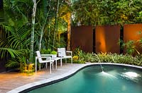 Petit jardin urbain avec beaucoup d'intimité grâce aux murs et à la plantation, les caractéristiques comprennent: piscine, terrasse en bois et coin salon