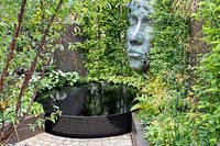 'The Thrive Reflective Mind 'jardin avec étang surélevé, parterre de fleurs surélevé et sculpture