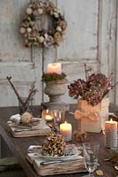 Hortensia séché et table de livre vintage et couverts avec bougies et couronne de porte
