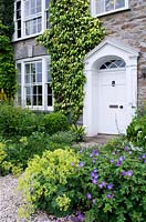 Porte d'entrée entourée de massifs de fleurs vivaces. Bosvigo House, Cornwall, Royaume-Uni.