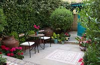 Paire de chaises à petite table ronde dans une cour d'inspiration marocaine.