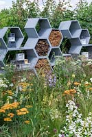 Un mur en nid d'abeilles contenant des brindilles pour encourager les abeilles solitaires, entouré de fleurs riches en nectar. The Urban Pollinator Garden, conçu par Caitlin McLaughlin. RHS Hampton Court Palace Garden Festival, 2019.