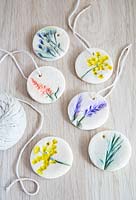 Étiquettes cadeaux en pâte à sel décorées d'impressions de fleurs puis peintes