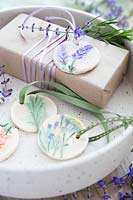 Cadeau enveloppé d'étiquettes cadeaux en pâte à sel et fleurs pressées peintes