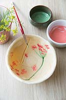 Empreintes de fleurs fraîchement peintes sur un bol de pâte à sel