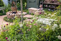 Plantation naturaliste colorée, un siège mural en pierre sèche et un foyer en pierre sèche. RHS Hampton Court Palace Garden Festival 2019. Commanditaire: Belvoir Fruit Farms.