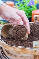 Femme remplissant des pots biodégradables avec du compost