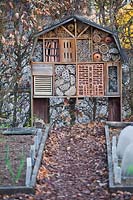Maison à insectes sur supports en bois dans un potager