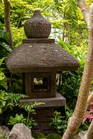 Une lanterne de pierre parmi les troncs d'Acer et l'euphorbe japonaise - Pachysandra terminalis. Le jardin Green Switch. RHS Chelsea Flower Show 2019