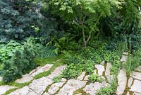 Le vert est le jardin de couleur, des combinaisons de plantation de feuillage entre la pierre et en parterre de fleurs mélangé.