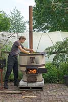 Pépinière de gui - organisation des fruits dans une chaudière en cuivre avec feu.