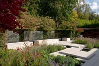 Vue sur le jardin de la ville moderne, avec un pavage et des plantations pâles montrant la couleur d'automne.