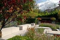 Vue sur le jardin de la ville moderne, avec un pavage et des plantations pâles montrant la couleur d'automne.