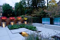 Vue sur le jardin de la ville moderne, avec des jardinières, éclairé par un éclairage contemporain au crépuscule