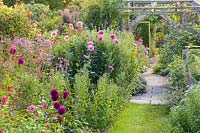 Le jardin Lanhydrock, Wollerton Old Hall Garden, Shropshire, Royaume-Uni. Le jardin cadran solaire avec sa pergola en bois. La plantation comprend: Dahlias, Phlox paniculata, Eupatoriums et Salvias
