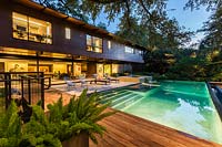 Vue sur terrasse en bois, piscine, terrasse vers maison contemporaine