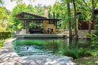 Les gens nager dans l'étang de baignade à Mill Creek Ranch à Vanderpool, Texas conçu par Ten Eyck Landscape Inc, juillet.