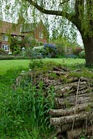 Pile de bois sous le saule agissant comme un refuge pour la faune - NGS Open Garden Day 2016, Iken, Suffolk