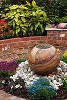 Zone pavée circulaire avec plan d'eau central et sièges - Jardin d'exposition «À la fin de la journée», Silver Gilt Award, Harrogate Spring Flower Show 2013