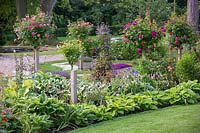 Parterre de fleurs mélangé avec diverses roses standard dans le jardin privé de David Austin Jnr