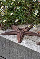 Une vieille étoile de mer en fer repose sur une poutre en bois.