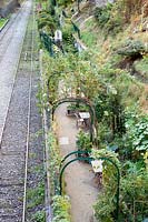 Arches métalliques supportant des arbustes sur un chemin longeant les voies ferrées. Parc de Ruisseau, Paris