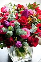 Bouquet floral utilisant des tulipes, des roses, des feuilles d'eucalyptus et de l'anémone.