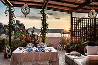 Salon et salle à manger en plein air sur terrasse avec vue sur le château et le port de Lerici au coucher du soleil