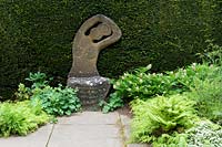 Chemin menant au siège en pierre sculpturale de Taxus haie