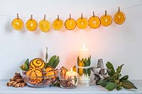 Étagère ornée d'oranges clou de girofle et Laurus nobilis - Bay - décorations, au-dessus de tranches d'orange chevillées sur une ligne