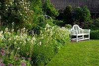 Banc de Lutyens blanc dans le coin du jardin du chalet.