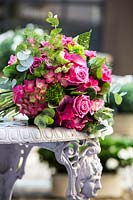 Bouquet de fleurs roses, dont des roses, des feuilles d'hortensia, de Dianthus et d'eucalyptus.