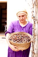 Femme tenant un panier de noix d'argan récoltées