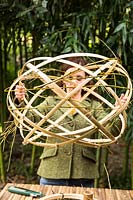 Femme tenant un abat-jour en bambou tissé à la main