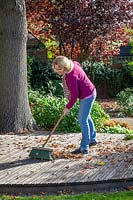 Balayer les feuilles tombées des terrasses en bois avec une brosse au début de l'automne pour éviter qu'elles ne glissent