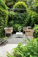 Un coin privé du jardin avec des sièges projetés par Phyllostachys bissetii - Bambou, Hedera hibernica - Lierre et Hydrangea quercifolia 'Pee Wee'