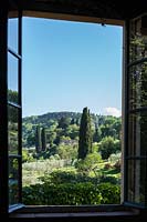 La vue à travers une fenêtre sur le paysage ombrien avec Cupressus sempervirens - Cyprès - arbres et Olea europae - Olivier - arbres