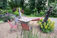 Un hamac dans un jardin de gravier avec table et chaises